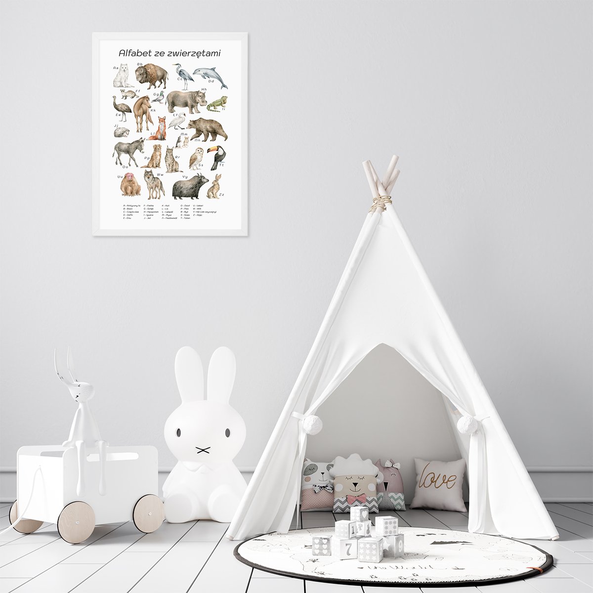 Plakat edukacyjny do przedszkola z alfabetem i nazwami dzikich zwierząt w białej ramce