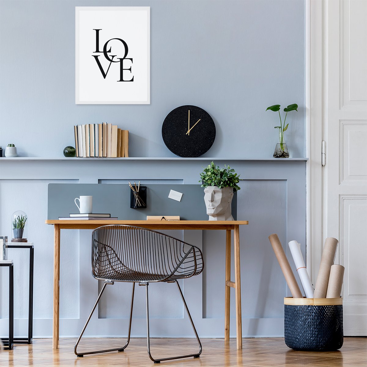 Plakat z tekstem w białej ramce powieszony nad biurkiem w domowym biurze