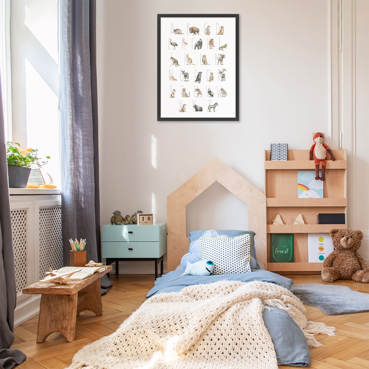 Plakat 50x70 cm z alfabetem i zwierzętami oprawiony w czarna ramkę w pokoju dziecięcym