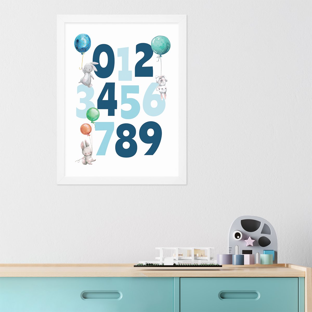 Plakat z niebieskimi cyframi i króliczkami w białej ramie wiszący w pokoju pierwszoklasisty#kolor_kolorowy