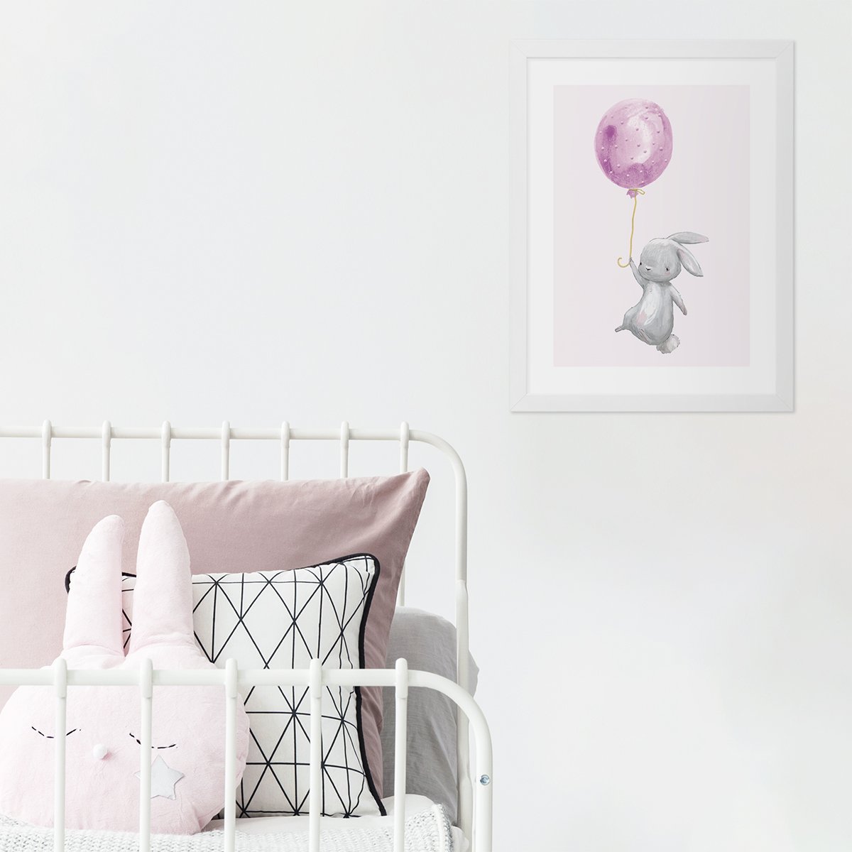 Plakat dla dziewczynki z króliczkiem trzymającym różowy balonik oprawiony w białą ramkę powieszony przy dziecięcym łóżku - pomysł na dekorację ścian pokoju dziewczynki#kolor_rozowy