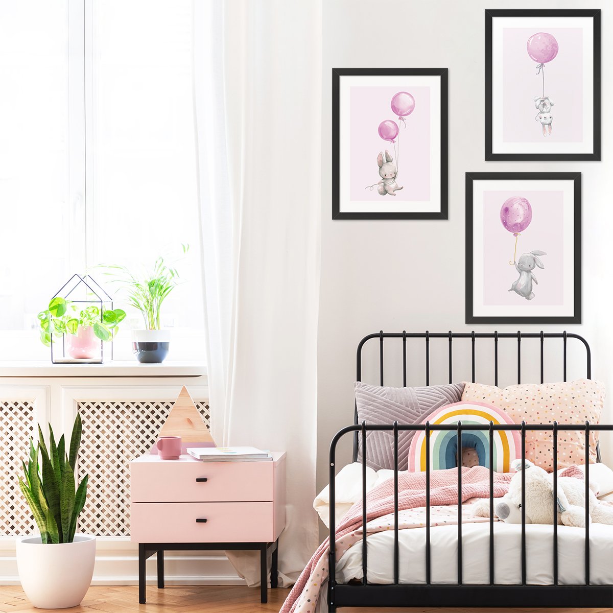Trzy różowe plakaty do pokoju dzieci z królikami i balonami z czarnymi ramkami powieszone nad łóżkiem w pokoju dziecięcym - inspirację na ozdobienie pustych ścian pokoju dziewczynki #kolor_rozowy