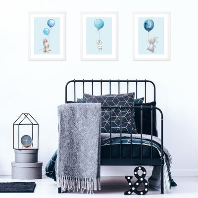 Plakaty na ścianę z królikami i niebieskimi balonami  powieszone nad łóżkiem w pokoju dziecięcym - zestaw trzech sztuk plakatów#kolor_niebieski