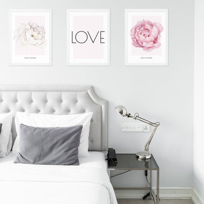 Plakaty na ściany kwiaty piwonie i napis LOVE oprawione w białe ramki powieszone nad łóżkiem w sypialni#kolor_rozowy