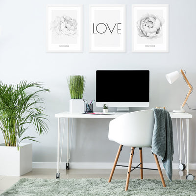 Plakaty z kwiatami w białych ramkach do domowego biura powieszone nad stolikiem z komuterem#kolor_szary